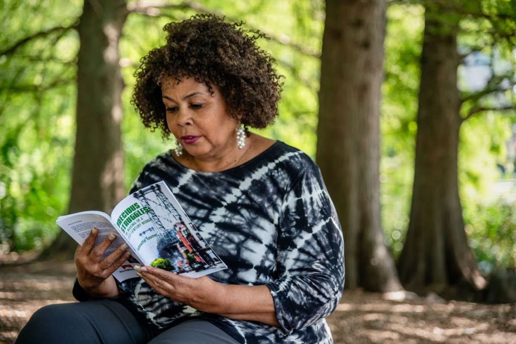 Jeanette Toomer reads from her book “Precious Struggles: The Making of a 21st Century Woman” in New York’s Central Park near her home. (Michael Kodas/Inside Climate News)