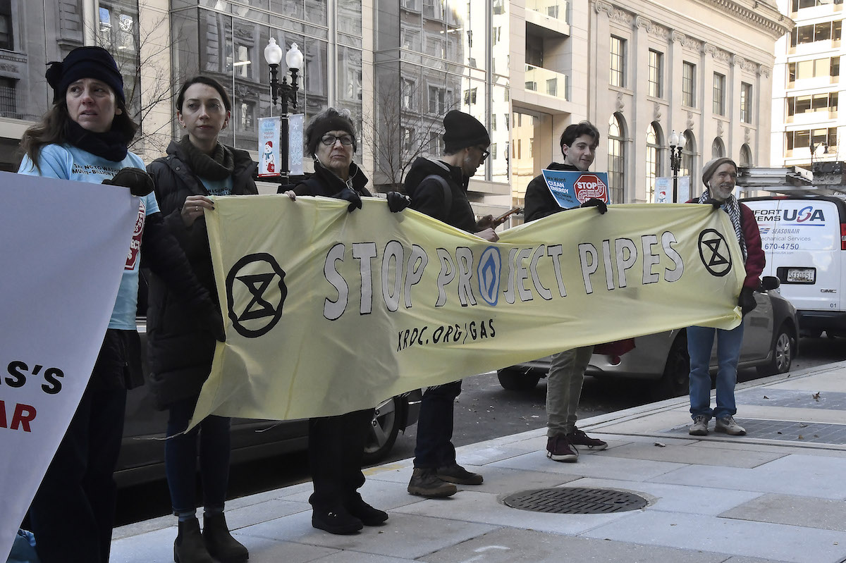 Climate activists gather outside the Public Service Commission’s office Dec. 20, when the commission voted to pause new funding for Washington Gas' PROJECTPipes. (Robert R. Roberts/The Washington Informer)
