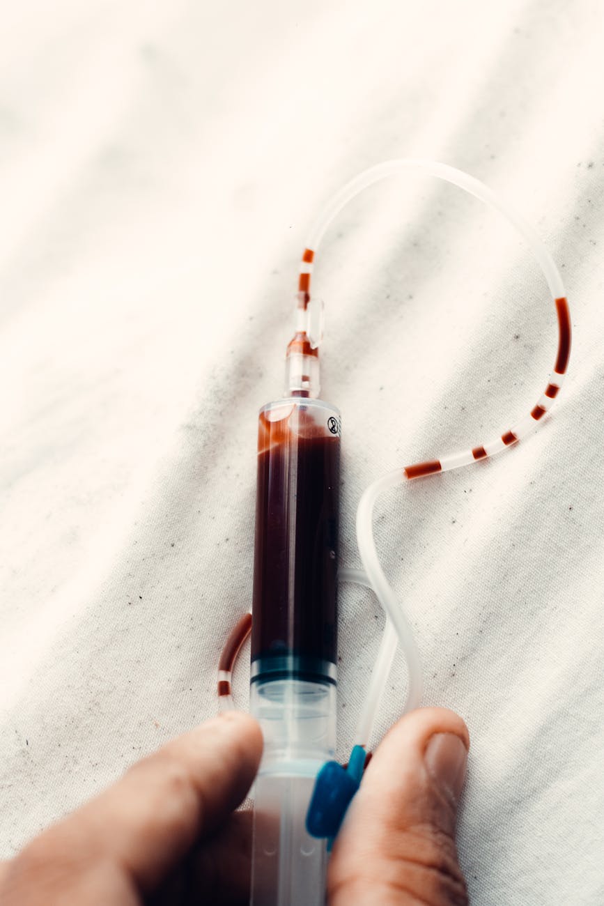 a person holding a syringe filled with blood