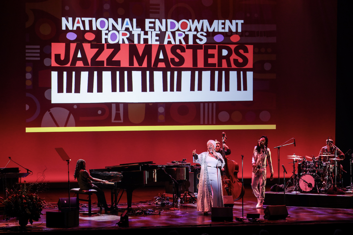 An all-star female jazz band closes out the 2024 Jazz Masters concert on April 13, at the Kennedy Center with a tribute celebrating “Ellington 125.” The band included pianist and D.C. native REDWOOD, vocalist Charenée Wade, saxophonist Lakecia Benjamin, bassist Katie Ernst, and drummer Camille Gainer. (Courtesy of Jati Lindsay)