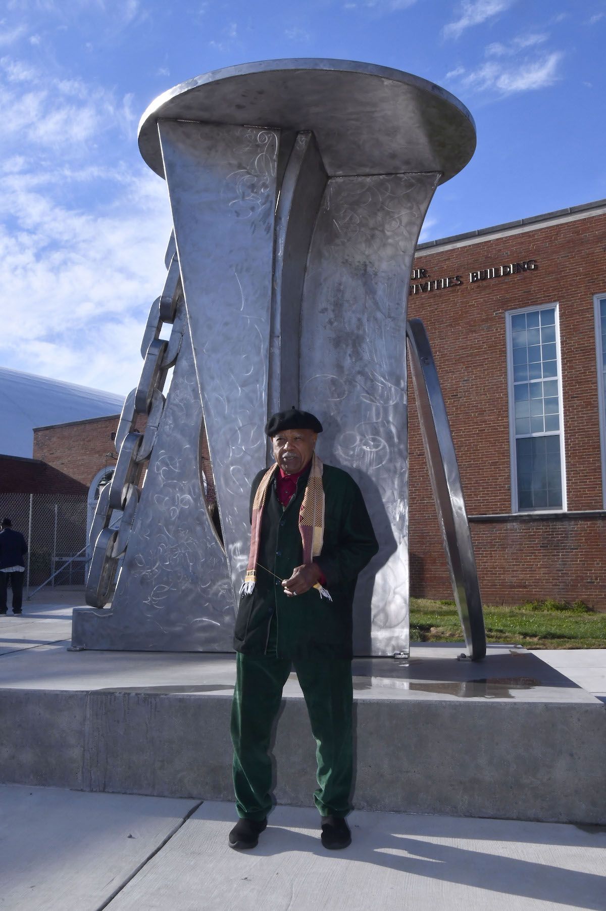 Artist Melvin Edwards stands on the University of Maryland campus in front of his sculpture “David’s Dream,” which honors the legacy of artist and educator David C. Driskell. (Robert R. Roberts/The Washington Informer)