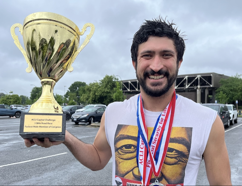 Greg Casar smiles with the winning trophy in hand after finishing the three-mile race in under 20 minutes. (Courtesy of ACLI)