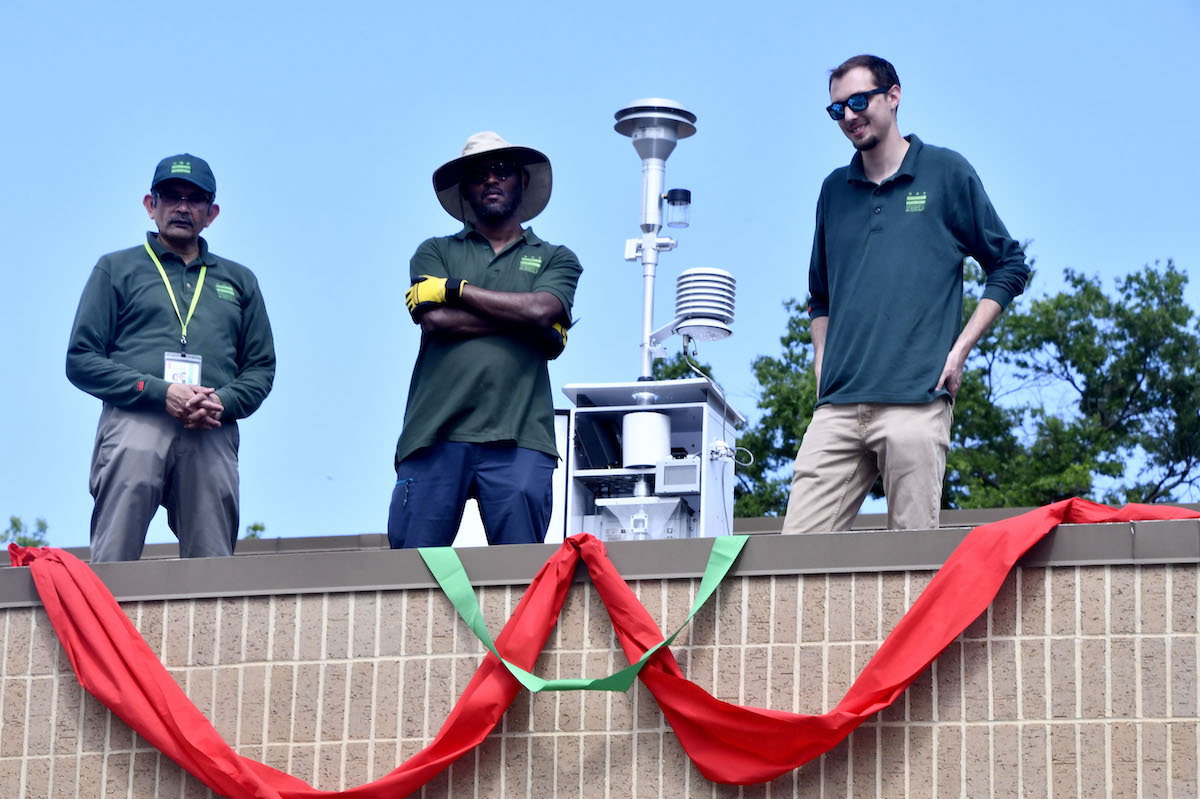 Members of the air quality monitoring team at the D.C. Department of Energy and Environment stand next to the new Ward 8 air quality monitor on the roof of Bald Eagle Recreation Center during the ribbon cutting May 7. (Robert R. Roberts/The Washington Informer)