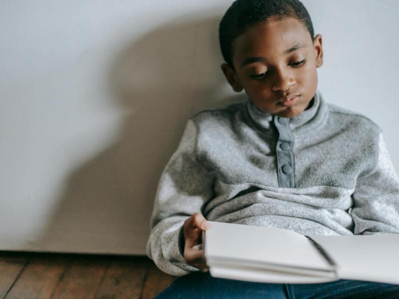 thoughtful black boy with copybook