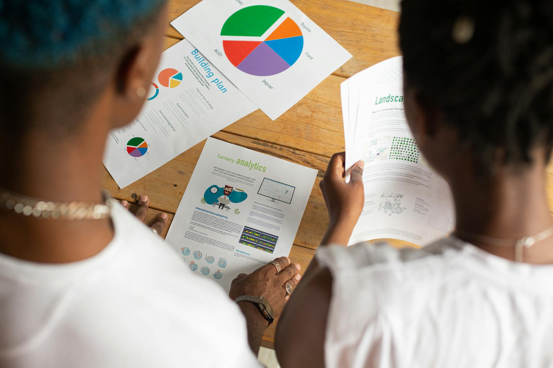 crop unrecognizable black coworkers analyzing diagrams