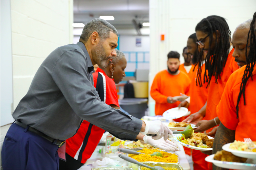 Industrial Bank President B. Doyle Mitchell Jr. helps serve food to inmates. (Tyler Palmer/Department of Corrections)
