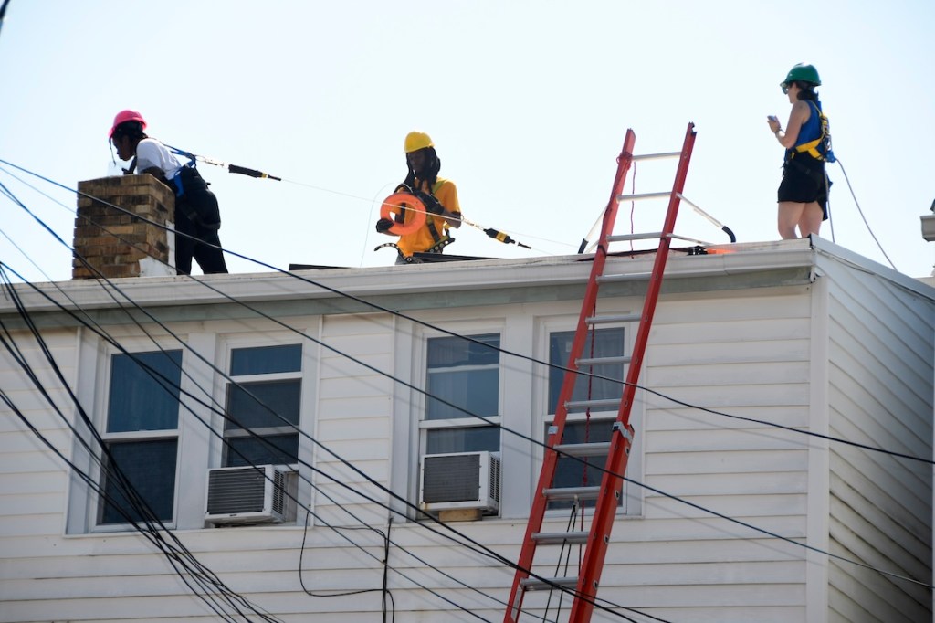 Getting the story on solar panel installations from the roof of a home in Petworth on July 13, 2023. (Robert R. Roberts/The Washington Informer)