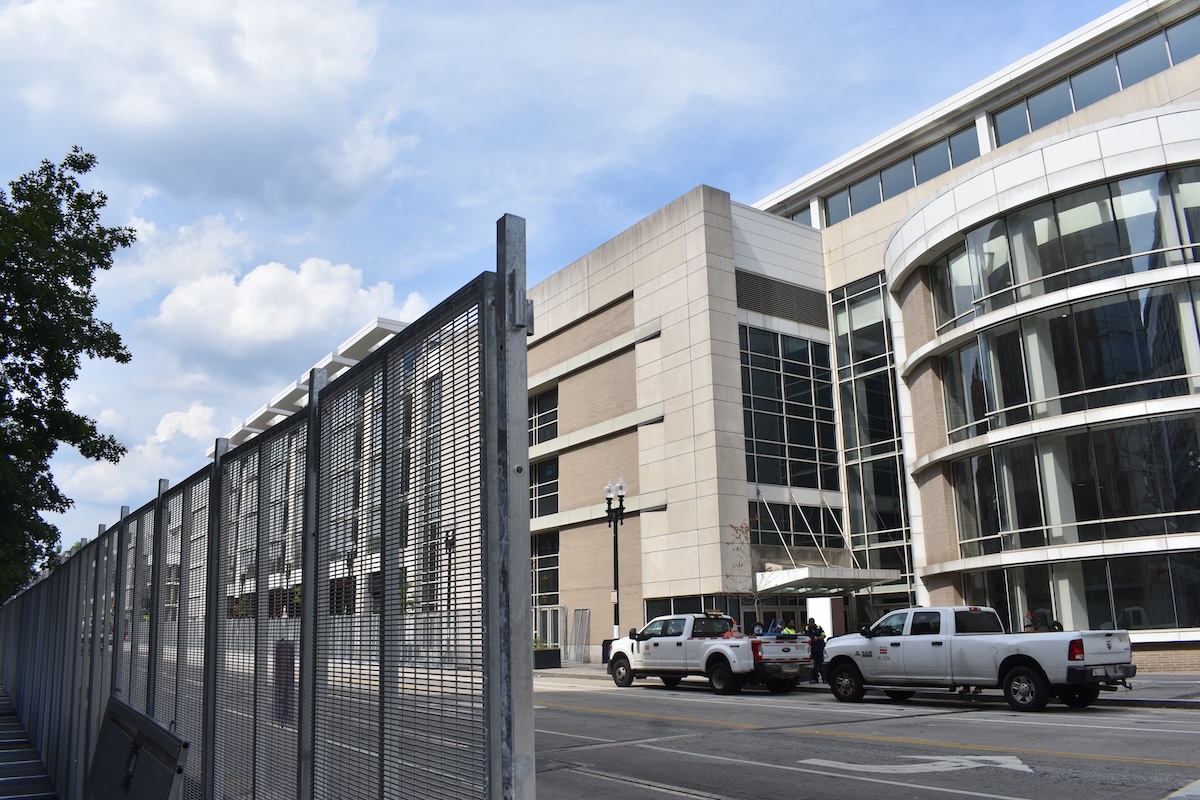 Workers take a break from assembling fences to block off streets and sidewalks around the Walter E. Washington Convention Center in Washington, D.C., ahead of the NATO summit on July 8, 2024. (Juan Benn Jr./The Washington Informer)