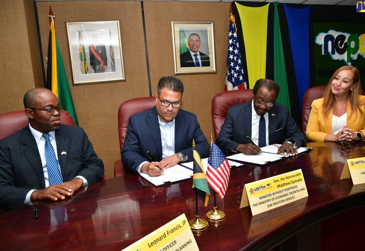 Minister without Portfolio in the Ministry of Economic Growth and Job Creation the Hon. Matthew Samuda (center left), and United States Ambassador to Jamaica His Excellency N. Nickolas Perry (center right), sign a $61-million grant agreement on Wednesday, July 31. Leonard Francis (left) Lambrini Kolios (right) serve as witnesses. (Courtesy photo)