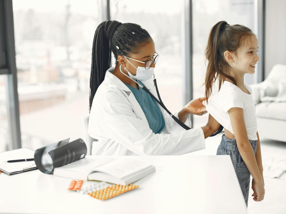 a doctor checking up the girl using stethoscope