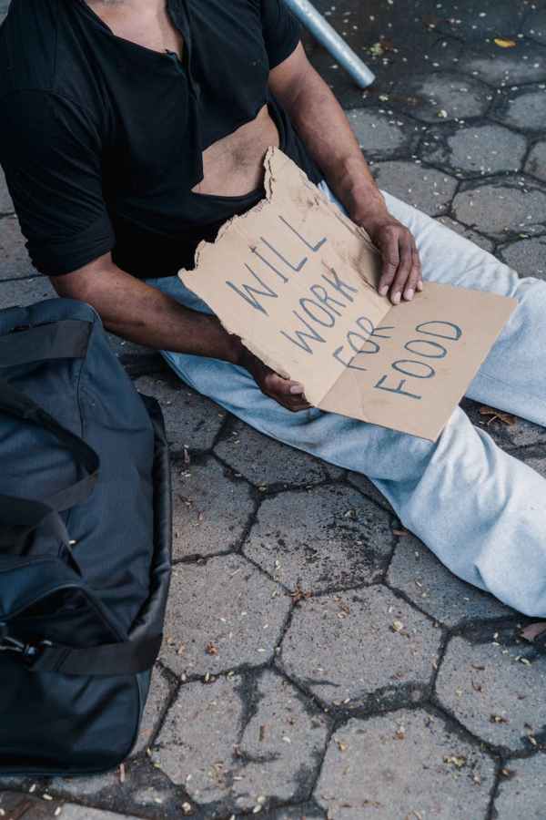 man in black t shirt and blue denim jeans holding white printer paper